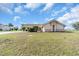 Expansive lawn view of a single-story home featuring a tile roof, neutral stucco exterior, and well-maintained landscaping at 5061 Richmond Ter, North Port, FL 34287