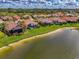 Overhead shot displaying homes by a pond, featuring verdant lawns and screened patios in a serene community at 5151 Pine Shadow Ln, North Port, FL 34287