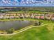 Aerial view of homes surrounding a pond in a community with mature trees and landscaping at 5151 Pine Shadow Ln, North Port, FL 34287