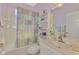 Bright bathroom features a shower/tub combo and a vanity with a sink and decorative shelf at 5151 Pine Shadow Ln, North Port, FL 34287