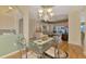 Bright dining room featuring a decorative chandelier, glass table, and hardwood flooring at 5151 Pine Shadow Ln, North Port, FL 34287