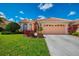 Charming home exterior featuring a two-car garage and well-kept landscaping at 5151 Pine Shadow Ln, North Port, FL 34287