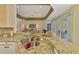 Bright kitchen featuring granite countertops, stainless steel sink and view to the living room at 5151 Pine Shadow Ln, North Port, FL 34287