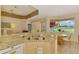 Bright kitchen features a breakfast bar with seating and scenic views of the lake and golf course at 5151 Pine Shadow Ln, North Port, FL 34287