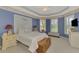 Spacious main bedroom with tray ceilings, serene blue walls, and plantation shutters at 5151 Pine Shadow Ln, North Port, FL 34287