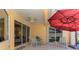 Covered patio with stylish seating overlooks the pool and lake at 5151 Pine Shadow Ln, North Port, FL 34287