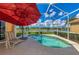 Inviting pool with an umbrella, sun lounger and serene waterfront views at 5151 Pine Shadow Ln, North Port, FL 34287