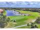 Picturesque aerial view of golf course community with ponds and lush landscaping at 560 Misty Pine Dr, Venice, FL 34292