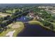 Aerial view of the community featuring a golf course, lake, and amenity center with a pool and clubhouse at 560 Misty Pine Dr, Venice, FL 34292