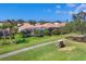 Backyard view of lush landscaping, golf cart path, and screened in patios of nearby homes at 560 Misty Pine Dr, Venice, FL 34292