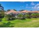 Backyard view features lush landscaping, a screened-in patio, and mature palm trees at 560 Misty Pine Dr, Venice, FL 34292