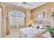 Inviting bedroom with a wrought iron bed frame and a peaceful, sunlit window view at 560 Misty Pine Dr, Venice, FL 34292