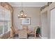 Cozy dining area features a round table with seating for four, a stylish chandelier, and ample natural light at 560 Misty Pine Dr, Venice, FL 34292