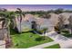 Beautiful single-story home with a well-manicured lawn, palm trees and a view of the golf course at 560 Misty Pine Dr, Venice, FL 34292