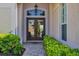 Inviting double front doors with glass panels, framed by lush green landscaping and stone walkway at 560 Misty Pine Dr, Venice, FL 34292