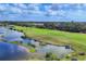 Beautiful golf course featuring a tranquil pond, lush landscaping, and golf carts at 560 Misty Pine Dr, Venice, FL 34292