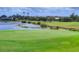 Scenic golf course view features a pristine green, a tranquil pond, and lush landscaping at 560 Misty Pine Dr, Venice, FL 34292
