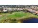 Scenic golf course view featuring a pristine green, a tranquil pond, and mature landscaping at 560 Misty Pine Dr, Venice, FL 34292
