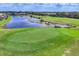 Scenic golf course view features a pristine green, a tranquil pond, and lush landscaping at 560 Misty Pine Dr, Venice, FL 34292