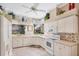 Well-lit kitchen with white cabinets, modern appliances, and tile backsplash offers a functional and stylish cooking space at 560 Misty Pine Dr, Venice, FL 34292