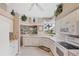 Bright, functional kitchen featuring white cabinets, tile countertops, and modern appliances with a scenic view from the window at 560 Misty Pine Dr, Venice, FL 34292