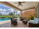 Screened lanai features outdoor seating area with a view of the pool and golf course at 560 Misty Pine Dr, Venice, FL 34292