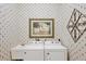 Charming laundry room with washer, dryer, sink, and a nature-themed wallpaper with complementary artwork at 560 Misty Pine Dr, Venice, FL 34292