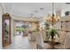 Inviting living room and dining area with golf course view and travertine floors at 560 Misty Pine Dr, Venice, FL 34292