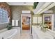 The bright bathroom offers an oversized tub, double sinks, and stylish tile flooring at 560 Misty Pine Dr, Venice, FL 34292