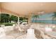 Covered patio with tables, chairs, ceiling fans, and tropical-themed mural at 560 Misty Pine Dr, Venice, FL 34292