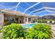 Relaxing screened-in pool area with lounge chairs and lush landscaping at 560 Misty Pine Dr, Venice, FL 34292