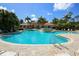 Community pool with fountain feature, lounge chairs, and nearby clubhouse at 560 Misty Pine Dr, Venice, FL 34292