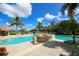 Community pool with fountain feature, palm trees, and several lounge chairs at 560 Misty Pine Dr, Venice, FL 34292