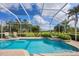 Sparkling pool with spa and screened enclosure, surrounded by lush landscaping and golf course views at 560 Misty Pine Dr, Venice, FL 34292