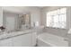 Bright bathroom features a granite countertop vanity, a soaking tub, and a glass-enclosed shower at 5767 Woodland Sage Dr, Sarasota, FL 34238