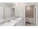 Well-lit bathroom with double sinks and a shower-tub combination, offering modern convenience at 5767 Woodland Sage Dr, Sarasota, FL 34238