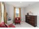 Cozy bedroom with neutral walls, a dark wood dresser, and accent chair at 5767 Woodland Sage Dr, Sarasota, FL 34238