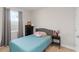 Cozy bedroom with a soft blue comforter, side table, and a window for natural light at 5767 Woodland Sage Dr, Sarasota, FL 34238