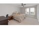 Comfortable bedroom with a ceiling fan, plush bed, and natural light from the window at 5767 Woodland Sage Dr, Sarasota, FL 34238