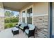 Inviting front porch with stylish seating, stone accents, and ample natural light at 5767 Woodland Sage Dr, Sarasota, FL 34238
