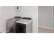 Efficient laundry room features side-by-side washer and dryer, plus a storage shelf at 5767 Woodland Sage Dr, Sarasota, FL 34238