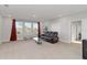 Spacious living room with carpet, large windows, and a comfortable leather sofa at 5767 Woodland Sage Dr, Sarasota, FL 34238
