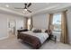 Serene main bedroom features a tray ceiling, plush carpet, and natural light at 5767 Woodland Sage Dr, Sarasota, FL 34238