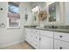 Bathroom featuring double sink vanity, decorative mirrors and accents, and granite countertops at 612 Poinsettia Dr, Venice, FL 34285