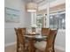 Cozy breakfast nook featuring a glass table, wicker chairs, and a stylish light fixture at 612 Poinsettia Dr, Venice, FL 34285