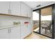 Bright kitchen area with built-in cabinets and sliding glass doors to balcony at 6415 Midnight Pass Rd # 909, Sarasota, FL 34242