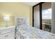 Bright bedroom featuring a twin bed and sliding glass doors to balcony at 6415 Midnight Pass Rd # 909, Sarasota, FL 34242