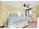 Bright bedroom with a ceiling fan, balcony access, and colorful bedding at 6415 Midnight Pass Rd # 909, Sarasota, FL 34242