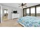 Bright bedroom with a dresser, ceiling fan, balcony access, and colorful bedding at 6415 Midnight Pass Rd # 909, Sarasota, FL 34242