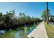 Waterfront property features a wooden dock with tropical surroundings at 6415 Midnight Pass Rd # 909, Sarasota, FL 34242